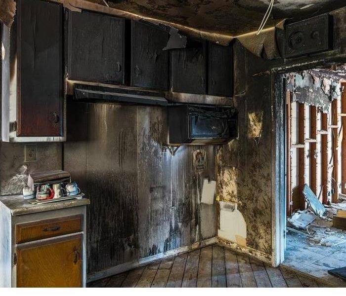 A badly burned kitchen, gutted and covered in soot and ash