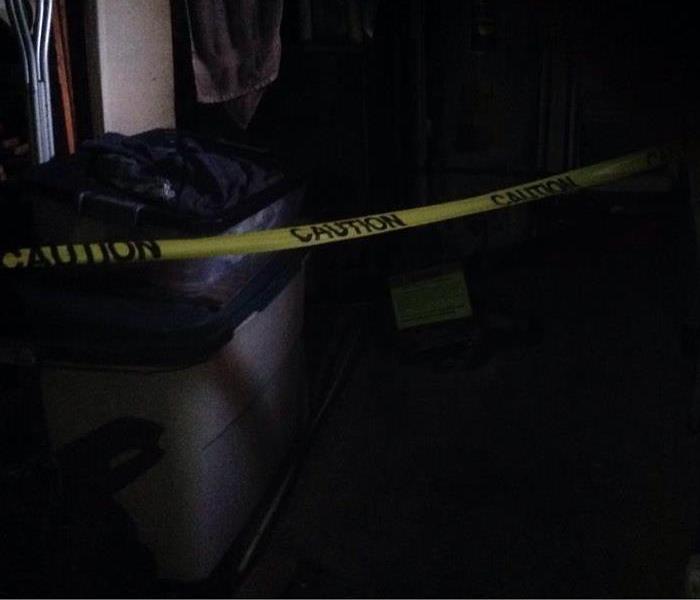 A soot covered room lined with caution tape